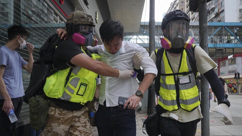 Riot police detain a protester during a demonstration against Beijing's national security legislation in Causeway Bay in Hong Kong, Sunday, May 24, 2020. Hong Kong police fired volleys of tear gas in a popular shopping district as hundreds took to the streets Sunday to march against China's proposed tough national security legislation for the city. (AP Photo/Vincent Yu)