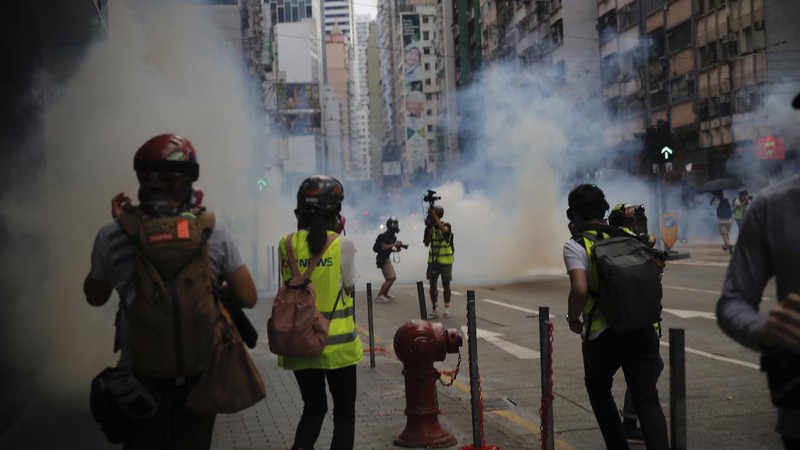 Riot police detain a protester during a demonstration against Beijing's national security legislation in Causeway Bay in Hong Kong, Sunday, May 24, 2020. Hong Kong police fired volleys of tear gas in a popular shopping district as hundreds took to the streets Sunday to march against China's proposed tough national security legislation for the city. (AP Photo/Vincent Yu)