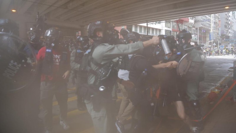 Riot police detain a protester during a demonstration against Beijing's national security legislation in Causeway Bay in Hong Kong, Sunday, May 24, 2020. Hong Kong police fired volleys of tear gas in a popular shopping district as hundreds took to the streets Sunday to march against China's proposed tough national security legislation for the city. (AP Photo/Vincent Yu)