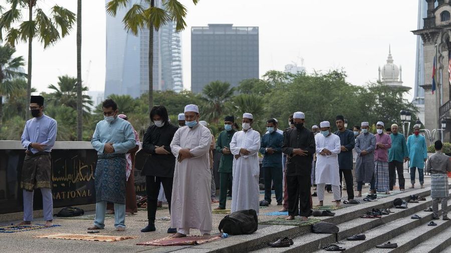 Worshippers wearing protective face masks offer Eid al-Fitr prayers outside a mosque to help prevent the spread of the coronavirus, in Tehran, Iran, Sunday, May 24, 2020. Muslims worldwide celebrate one of their biggest holidays under the long shadow of the coronavirus, with millions confined to their homes and others gripped by economic concerns during what is usually a festive time of shopping and celebration. In Iran, which has endured the deadliest outbreak in the Middle East, authorities have imposed few restrictions ahead of the holiday aside from cancelling mass prayers in Tehran traditionally led by Supreme Leader Ayatollah Ali Khamenei. (AP Photo/Vahid Salemi)
