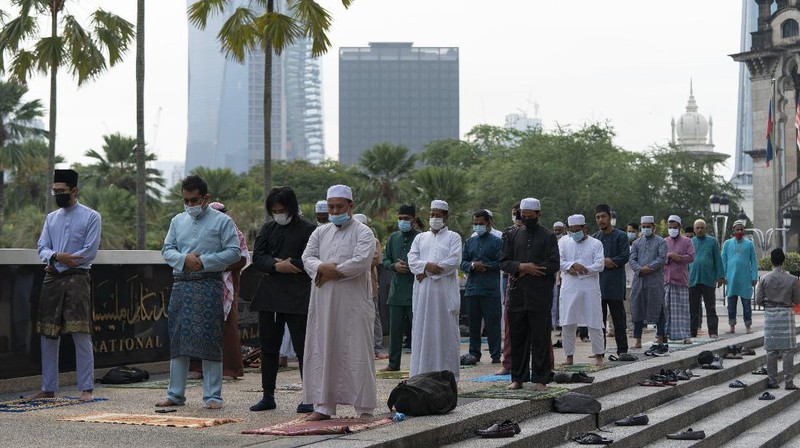 Worshippers wearing protective face masks offer Eid al-Fitr prayers outside a mosque to help prevent the spread of the coronavirus, in Tehran, Iran, Sunday, May 24, 2020. Muslims worldwide celebrate one of their biggest holidays under the long shadow of the coronavirus, with millions confined to their homes and others gripped by economic concerns during what is usually a festive time of shopping and celebration. In Iran, which has endured the deadliest outbreak in the Middle East, authorities have imposed few restrictions ahead of the holiday aside from cancelling mass prayers in Tehran traditionally led by Supreme Leader Ayatollah Ali Khamenei. (AP Photo/Vahid Salemi)