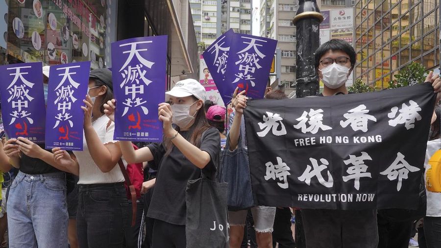 Riot police detain a protester during a demonstration against Beijing's national security legislation in Causeway Bay in Hong Kong, Sunday, May 24, 2020. Hong Kong police fired volleys of tear gas in a popular shopping district as hundreds took to the streets Sunday to march against China's proposed tough national security legislation for the city. (AP Photo/Vincent Yu)