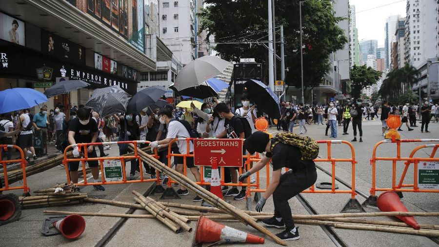 Riot police detain a protester during a demonstration against Beijing's national security legislation in Causeway Bay in Hong Kong, Sunday, May 24, 2020. Hong Kong police fired volleys of tear gas in a popular shopping district as hundreds took to the streets Sunday to march against China's proposed tough national security legislation for the city. (AP Photo/Vincent Yu)