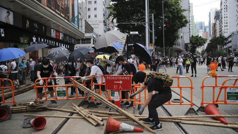 Riot police detain a protester during a demonstration against Beijing's national security legislation in Causeway Bay in Hong Kong, Sunday, May 24, 2020. Hong Kong police fired volleys of tear gas in a popular shopping district as hundreds took to the streets Sunday to march against China's proposed tough national security legislation for the city. (AP Photo/Vincent Yu)
