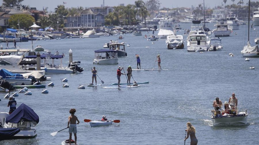 Visitors gather on the beach Sunday, May 24, 2020, in Newport Beach, Calif., during the coronavirus outbreak. (AP Photo/Marcio Jose Sanchez)