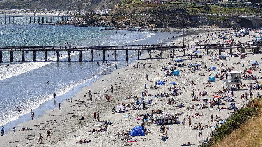 This Saturday, May 23, 2020, photo, shows a view of Avila Beach from the cliffs in Pismo Beach, Calif. The beaches in Pismo Beach and Avila Beach, California, were fairly packed with tourists during Memorial Day weekend with the coronavirus pandemic still ongoing. (Laura Dickinson/The Tribune (of San Luis Obispo) via AP)