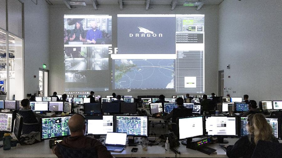 This Thursday, March 19, 2020 photo made available by SpaceX shows NASA astronauts Bob Behnken and Doug Hurley during flight simulator testing at the Kennedy Space Center in Cape Canaveral, Fla., with SpaceX teams in Firing Room 4 at NASA's Kennedy Space Center, SpaceX's Mission Control in Hawthorne, Calif., and NASA flight controllers in Mission Control Houston, for a full simulation of launch and docking of the Crew Dragon spacecraft. (SpaceX via AP)