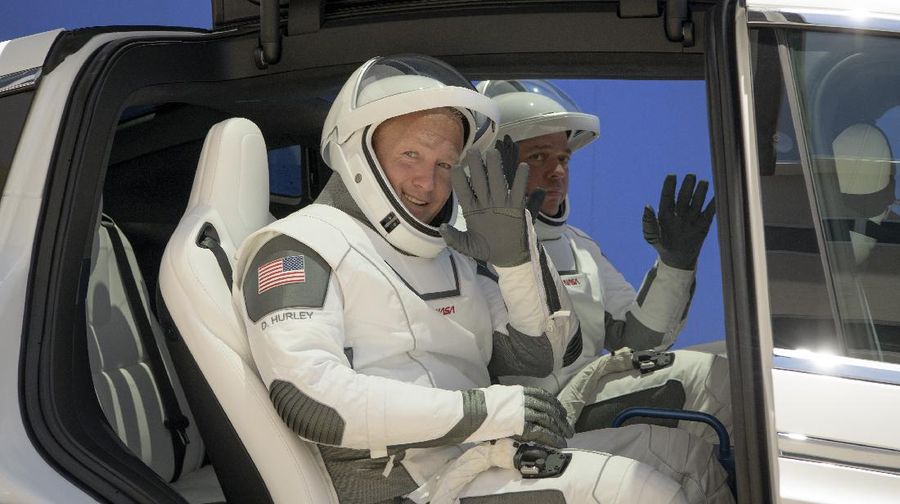 This Thursday, March 19, 2020 photo made available by SpaceX shows NASA astronauts Bob Behnken and Doug Hurley during flight simulator testing at the Kennedy Space Center in Cape Canaveral, Fla., with SpaceX teams in Firing Room 4 at NASA's Kennedy Space Center, SpaceX's Mission Control in Hawthorne, Calif., and NASA flight controllers in Mission Control Houston, for a full simulation of launch and docking of the Crew Dragon spacecraft. (SpaceX via AP)
