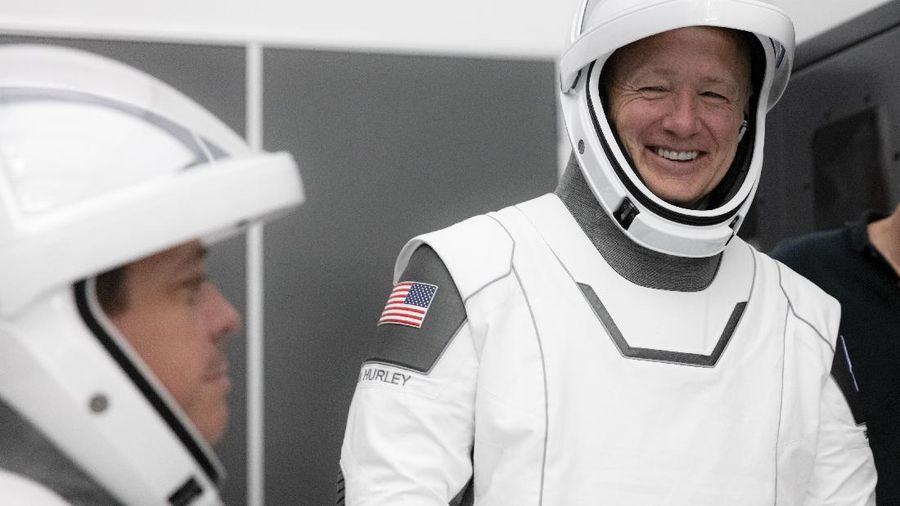 This Thursday, March 19, 2020 photo made available by SpaceX shows NASA astronauts Bob Behnken and Doug Hurley during flight simulator testing at the Kennedy Space Center in Cape Canaveral, Fla., with SpaceX teams in Firing Room 4 at NASA's Kennedy Space Center, SpaceX's Mission Control in Hawthorne, Calif., and NASA flight controllers in Mission Control Houston, for a full simulation of launch and docking of the Crew Dragon spacecraft. (SpaceX via AP)