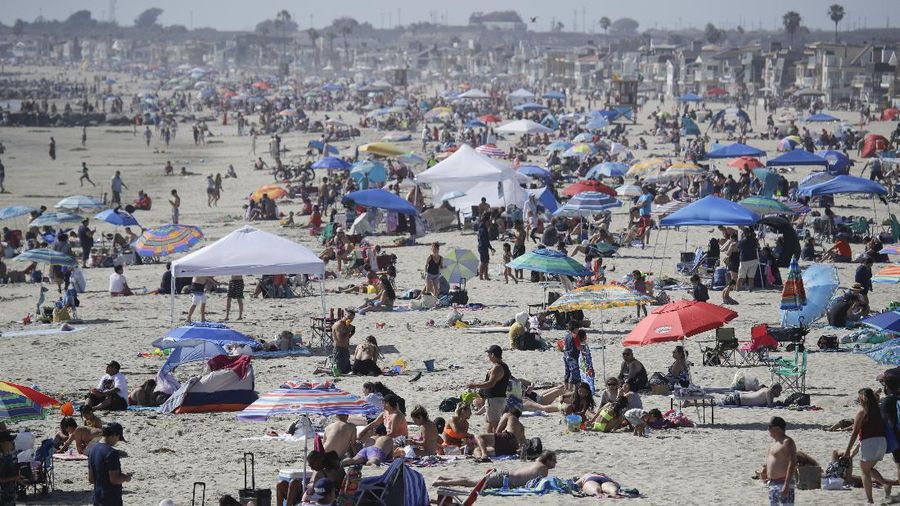 Visitors gather on the beach Sunday, May 24, 2020, in Newport Beach, Calif., during the coronavirus outbreak. (AP Photo/Marcio Jose Sanchez)