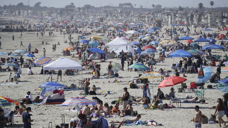 Visitors gather on the beach Sunday, May 24, 2020, in Newport Beach, Calif., during the coronavirus outbreak. (AP Photo/Marcio Jose Sanchez)