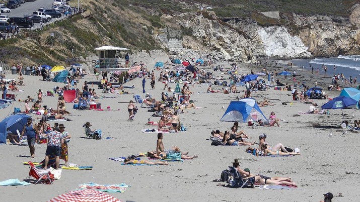This Saturday, May 23, 2020, photo, shows a view of Avila Beach looking south from the Avila Beach Pier in Pismo Beach, Calif. The beaches in Pismo Beach and Avila Beach, California, were fairly packed with tourists during Memorial Day weekend with the coronavirus pandemic still ongoing. (Laura Dickinson/The Tribune (of San Luis Obispo) via AP)