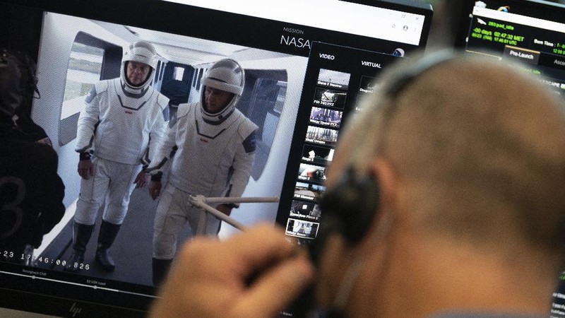This Thursday, March 19, 2020 photo made available by SpaceX shows NASA astronauts Bob Behnken and Doug Hurley during flight simulator testing at the Kennedy Space Center in Cape Canaveral, Fla., with SpaceX teams in Firing Room 4 at NASA's Kennedy Space Center, SpaceX's Mission Control in Hawthorne, Calif., and NASA flight controllers in Mission Control Houston, for a full simulation of launch and docking of the Crew Dragon spacecraft. (SpaceX via AP)