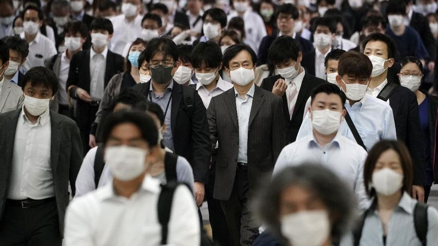 A station passageway is crowded with commuters wearing face mask during a rush hour Tuesday, May 26, 2020, in Tokyo.  Japanese Prime Minister Shinzo Abe lifted a coronavirus state of emergency in Tokyo and four other remaining prefectures on Monday, May 25, ending the declaration that began nearly eight weeks ago. (AP Photo/Eugene Hoshiko)