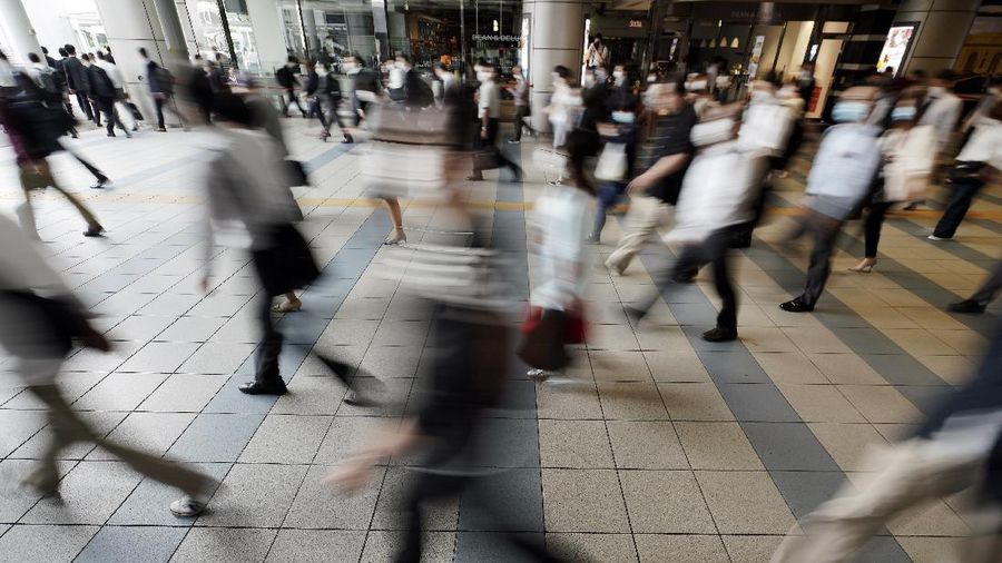 A station passageway is crowded with commuters wearing face mask during a rush hour Tuesday, May 26, 2020, in Tokyo.  Japanese Prime Minister Shinzo Abe lifted a coronavirus state of emergency in Tokyo and four other remaining prefectures on Monday, May 25, ending the declaration that began nearly eight weeks ago. (AP Photo/Eugene Hoshiko)