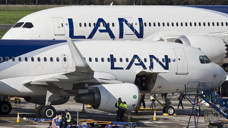 Two LAN jet liners sit parked on the tarmac at the airport in Santiago, Chile, Monday, July 25, 2016. LATAM airlines created in 2012 after a fusion between the airlines LAN of Chile and TAM of Brazil, has agreed to pay more than $22 million in fines related with a scheme to bribe Argentine union officials via a false consulting contract. The airline will pay the fine to the Securities and Exchange Commission (SEC) and the Department of Justice (DOJ) for a violation of the accounting provisions of the Foreign Corrupt Practices Act. (AP Photo/Esteban Felix)