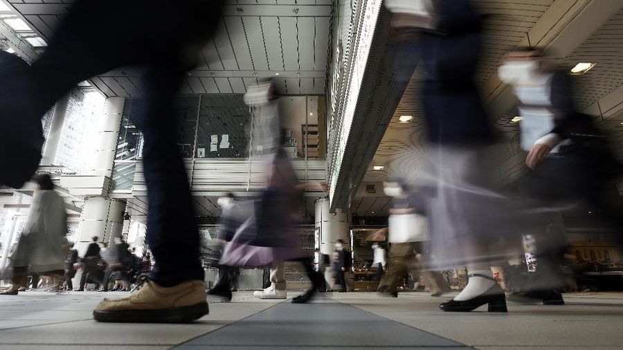 A station passageway is crowded with commuters wearing face mask during a rush hour Tuesday, May 26, 2020, in Tokyo.  Japanese Prime Minister Shinzo Abe lifted a coronavirus state of emergency in Tokyo and four other remaining prefectures on Monday, May 25, ending the declaration that began nearly eight weeks ago. (AP Photo/Eugene Hoshiko)