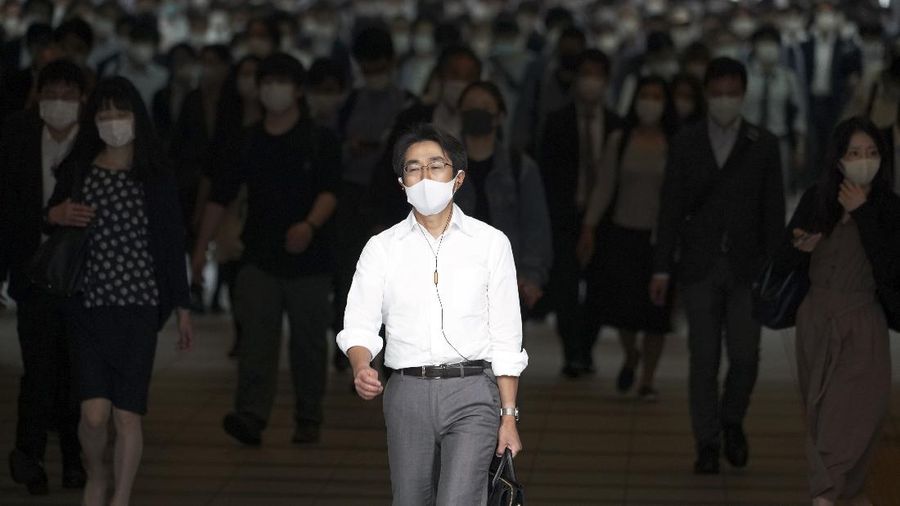 A station passageway is crowded with commuters wearing face mask during a rush hour Tuesday, May 26, 2020, in Tokyo.  Japanese Prime Minister Shinzo Abe lifted a coronavirus state of emergency in Tokyo and four other remaining prefectures on Monday, May 25, ending the declaration that began nearly eight weeks ago. (AP Photo/Eugene Hoshiko)