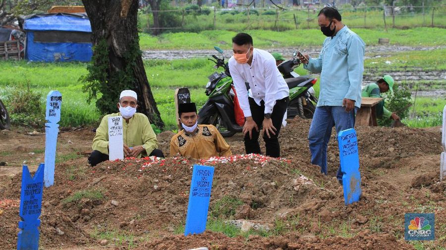 Taman Pemakaman Umum (TPU) Tegal Alur, Kalideres, Jakarta Barat, ramai oleh peziarah pada Hari Raya Idul Fitri 1441 Hijriyah, Ahad (26/5/20). Sejak pagi, keberadaan peziarah pada hari Lebaran ketiga tampak merata di blok pemakaman umum maupun blok makam khusus pasien Covid-19.
Terdapat pembatas garis polisi yang membedakan blok makam umum dan makam pasien Covid-19. TPU Tegal Alur diketahui merupakan salah satu makam yang khusus diperuntukkan jenazah pasien positif Covid-19.
Protokol kesehatan covid-19 diberlakukan secara ketat di kawasan TPU Tegal Alur. Peziarah wajib menggunakan masker dan mencuci tangan dengan sabun serta air mengalir. Selain itu, sebelum peziarah masuk dan keluar TPU Tegal Alur, terutama di blok makam pasien Covid-19, petugas melakukan disinfeksi kepada mereka.
Terik siang menyengat tak menghalangi niat peziarah berdoa di pusara keluarga yang telah wafat, seperti salah seorang pengunjung makam, Teguh (30). Bersama beberapa anggota keluarganya, Teguh berziarah ke makam ayahnya yang dimakamkan dengan protokol Covid-19 di TPU Tegal Alur.