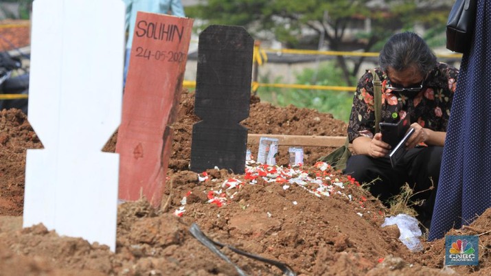 Ziarah di Taman Pemakaman Umum (TPU) Tegal Alur, Kalideres, Jakarta Barat. (CNBC Indonesia/ Tri Susilo) Taman Pemakaman Umum (TPU) Tegal Alur, Kalideres, Jakarta Barat, ramai oleh peziarah pada Hari Raya Idul Fitri 1441 Hijriyah, Ahad (26/5/20). Sejak pagi, keberadaan peziarah pada hari Lebaran ketiga tampak merata di blok pemakaman umum maupun blok makam khusus pasien Covid-19.
Terdapat pembatas garis polisi yang membedakan blok makam umum dan makam pasien Covid-19. TPU Tegal Alur diketahui merupakan salah satu makam yang khusus diperuntukkan jenazah pasien positif Covid-19.
Protokol kesehatan covid-19 diberlakukan secara ketat di kawasan TPU Tegal Alur. Peziarah wajib menggunakan masker dan mencuci tangan dengan sabun serta air mengalir. Selain itu, sebelum peziarah masuk dan keluar TPU Tegal Alur, terutama di blok makam pasien Covid-19, petugas melakukan disinfeksi kepada mereka.
Terik siang menyengat tak menghalangi niat peziarah berdoa di pusara keluarga yang telah wafat, seperti salah seorang pengunjung makam, Teguh (30). Bersama beberapa anggota keluarganya, Teguh berziarah ke makam ayahnya yang dimakamkan dengan protokol Covid-19 di TPU Tegal Alur.