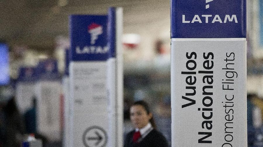 FILE - In this July 25, 2016, file photo, an agent of LATAM airlines stands by the counters at the airport in Santiago, Chile. The South American carrier said Tuesday, May 26, 2020, it is seeking Chapter 11 bankruptcy protection as it grapples with the sharp downturn in air travel sparked by the coronavirus pandemic. (AP Photo/Esteban Felix, File)