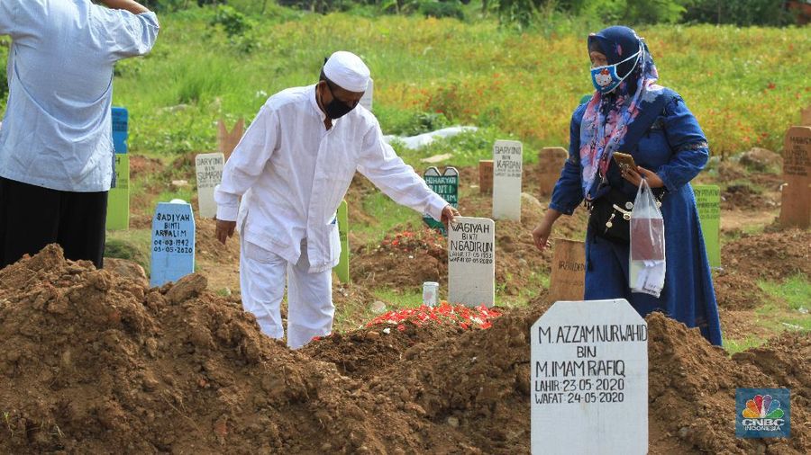 Taman Pemakaman Umum (TPU) Tegal Alur, Kalideres, Jakarta Barat, ramai oleh peziarah pada Hari Raya Idul Fitri 1441 Hijriyah, Ahad (26/5/20). Sejak pagi, keberadaan peziarah pada hari Lebaran ketiga tampak merata di blok pemakaman umum maupun blok makam khusus pasien Covid-19.
Terdapat pembatas garis polisi yang membedakan blok makam umum dan makam pasien Covid-19. TPU Tegal Alur diketahui merupakan salah satu makam yang khusus diperuntukkan jenazah pasien positif Covid-19.
Protokol kesehatan covid-19 diberlakukan secara ketat di kawasan TPU Tegal Alur. Peziarah wajib menggunakan masker dan mencuci tangan dengan sabun serta air mengalir. Selain itu, sebelum peziarah masuk dan keluar TPU Tegal Alur, terutama di blok makam pasien Covid-19, petugas melakukan disinfeksi kepada mereka.
Terik siang menyengat tak menghalangi niat peziarah berdoa di pusara keluarga yang telah wafat, seperti salah seorang pengunjung makam, Teguh (30). Bersama beberapa anggota keluarganya, Teguh berziarah ke makam ayahnya yang dimakamkan dengan protokol Covid-19 di TPU Tegal Alur.