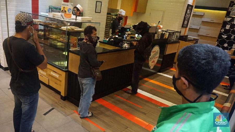 Pengunjung saat membeli makanan di Mall Summarecon Bekasi, Selasa (26/5). Pantauan CNBC Indonesia Summarecon Mall Bekasi hingga kini masih beroperasi secara terbatas imbas pandemi COVID-19. Hanya toko makanan dan farmasi yang buka di pusat perbelanjaan ini. Namun untuk gerai makanan tidak melayani makan di tempat. Usai Presiden RI Jokowi meninjau  mall Summarecon dalam waktu dekat siap beroperasi secara penuh karena kasus positif virus Corona di wilayah tersebut sudah landai dan dikategorikan zona hijau. Nantinya pengunjung mal bakal dibatasi hanya 50% dari kapasitas normal. Begitu pula dengan gerai-gerai yang ada di dalamnya, kapasitasnya hanya boleh 50% dari kondisi normal. (CNBC Indonesia/ Muhammad Sabki)