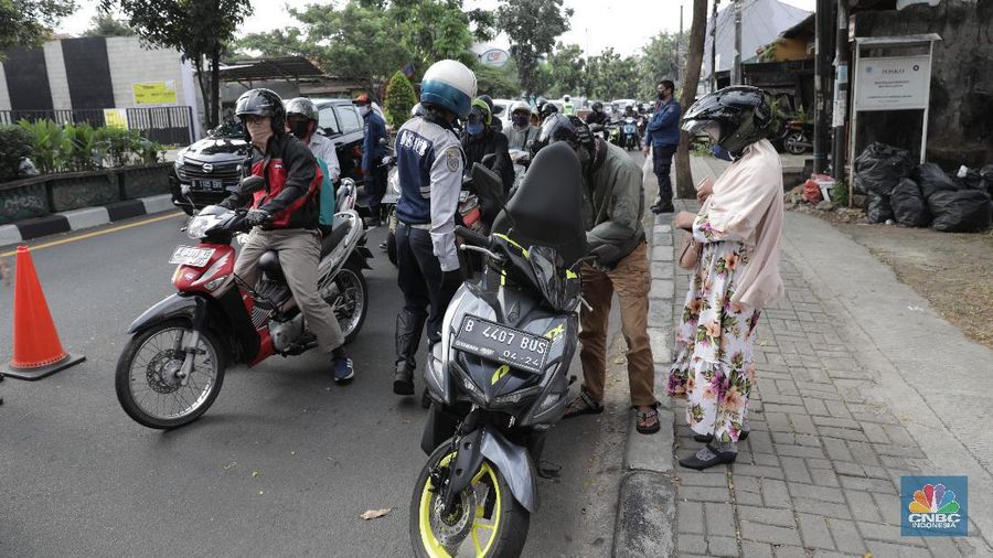 Petugas gabungan melakukan pemeriksaan di pos cek poin yang berada di PSBB Sandratek Tangerang Selatan, Rabu 27/5. Pelanggaran umumnya didominasi pengendara sepeda motor dalam kota. Petugas pos cek poin tak akan mentolerir jika saat pemeriksaan mendapati pengendara yang tengah melakukan perjalanan pulang mudik dari kampung halaman. Pos cek poin Sandratek merupakan salah satu titik yang menghubungkan akses Jakarta- Tangsel menuju Bogor, Jawa Barat. Petugas gabungan yang berjaga berasal dari 3 personil unsur kepolisian, 1 personil TNI, 10 personil Dinas Perhubungan, dan 1 orang petugas dari Dinas Kesehatan. Ramainya arus lalu lintas membuat petugas kewalahan memeriksa para melanggar yang melintas. 