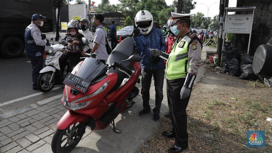 Petugas gabungan melakukan pemeriksaan di pos cek poin yang berada di PSBB Sandratek Tangerang Selatan, Rabu 27/5. Pelanggaran umumnya didominasi pengendara sepeda motor dalam kota. Petugas pos cek poin tak akan mentolerir jika saat pemeriksaan mendapati pengendara yang tengah melakukan perjalanan pulang mudik dari kampung halaman. Pos cek poin Sandratek merupakan salah satu titik yang menghubungkan akses Jakarta- Tangsel menuju Bogor, Jawa Barat. Petugas gabungan yang berjaga berasal dari 3 personil unsur kepolisian, 1 personil TNI, 10 personil Dinas Perhubungan, dan 1 orang petugas dari Dinas Kesehatan. Ramainya arus lalu lintas membuat petugas kewalahan memeriksa para melanggar yang melintas. 