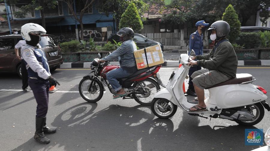 Petugas gabungan melakukan pemeriksaan di pos cek poin yang berada di PSBB Sandratek Tangerang Selatan, Rabu 27/5. Pelanggaran umumnya didominasi pengendara sepeda motor dalam kota. Petugas pos cek poin tak akan mentolerir jika saat pemeriksaan mendapati pengendara yang tengah melakukan perjalanan pulang mudik dari kampung halaman. Pos cek poin Sandratek merupakan salah satu titik yang menghubungkan akses Jakarta- Tangsel menuju Bogor, Jawa Barat. Petugas gabungan yang berjaga berasal dari 3 personil unsur kepolisian, 1 personil TNI, 10 personil Dinas Perhubungan, dan 1 orang petugas dari Dinas Kesehatan. Ramainya arus lalu lintas membuat petugas kewalahan memeriksa para melanggar yang melintas. 