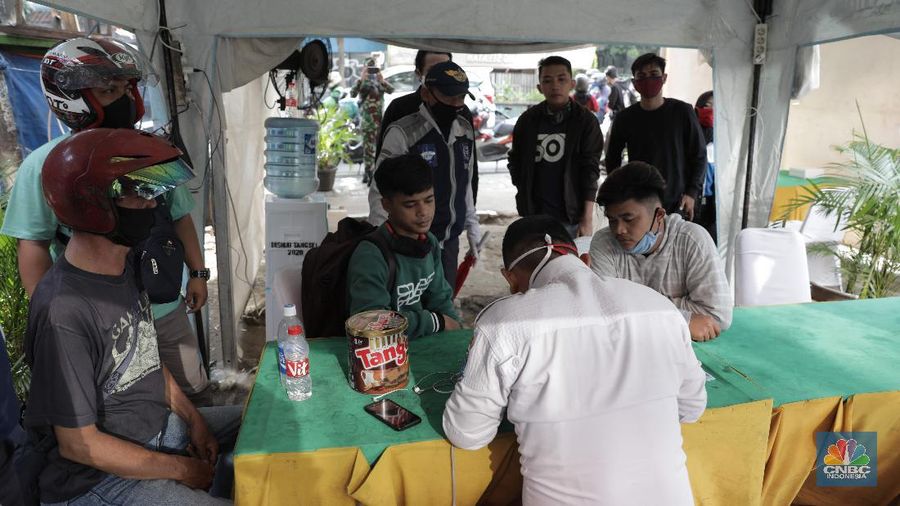 Petugas gabungan melakukan pemeriksaan di pos cek poin yang berada di PSBB Sandratek Tangerang Selatan, Rabu 27/5. Pelanggaran umumnya didominasi pengendara sepeda motor dalam kota. Petugas pos cek poin tak akan mentolerir jika saat pemeriksaan mendapati pengendara yang tengah melakukan perjalanan pulang mudik dari kampung halaman. Pos cek poin Sandratek merupakan salah satu titik yang menghubungkan akses Jakarta- Tangsel menuju Bogor, Jawa Barat. Petugas gabungan yang berjaga berasal dari 3 personil unsur kepolisian, 1 personil TNI, 10 personil Dinas Perhubungan, dan 1 orang petugas dari Dinas Kesehatan. Ramainya arus lalu lintas membuat petugas kewalahan memeriksa para melanggar yang melintas. 