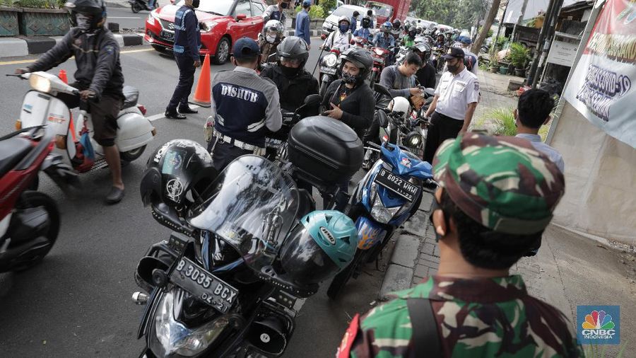 Petugas gabungan melakukan pemeriksaan di pos cek poin yang berada di PSBB Sandratek Tangerang Selatan, Rabu 27/5. Pelanggaran umumnya didominasi pengendara sepeda motor dalam kota. Petugas pos cek poin tak akan mentolerir jika saat pemeriksaan mendapati pengendara yang tengah melakukan perjalanan pulang mudik dari kampung halaman. Pos cek poin Sandratek merupakan salah satu titik yang menghubungkan akses Jakarta- Tangsel menuju Bogor, Jawa Barat. Petugas gabungan yang berjaga berasal dari 3 personil unsur kepolisian, 1 personil TNI, 10 personil Dinas Perhubungan, dan 1 orang petugas dari Dinas Kesehatan. Ramainya arus lalu lintas membuat petugas kewalahan memeriksa para melanggar yang melintas. 