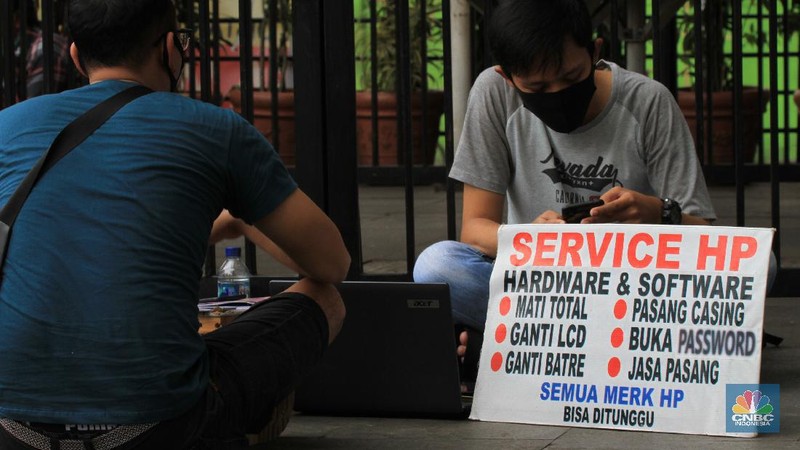 Suasana pekerja jasa servis telepon seluler di Pusat Grosir Cililitan (PGC), Jakarta Tmur, Kamis (28/5/2020). CNBC Indonesia/Tri Susilo
Wabah virus korona membuat masyarakat beraktivitas tidak seperti biasanya, seperti para penjual jasa servis telepon Pusat Grosir Cililitan (PGC) yang sampai turun ke jalan.

Pembatasan Sosial Berskala Besar (PSBB) menyebabkan para penjual jasa servis telepon genggam di PGC menawarkan jasanya sampai ke tepi jalan karena larangan membuka gerai di mal tersebut.

Para penjual jasa layanan yang dapat ditunggu, tidak hanya itu, mereka juga menyediakan jaminan untuk semua merek telepon keamanan.   

Para pemilik kios servis telepon genggam di Mall Pusat Grosir Cililitan (PGC) terpaksa menawarkan jasanya di pinggir jalan. Mereka harus tetap bayar biaya sewa kios 50 persen. Sementara pamasukan tidak ada.  

Indra memiliki 3 kios tempat servis HP di Mall PGC, dan telah bertahun-tahun menjalankan aktifitas menawarkan jasa tersebut. Dengan kondisi Pandemik Covid-19, selain berdiam diri dipinggir jalan menunggu pelanggan, ia juga menggunakan cara promosi dan pemberitahuan lewat media sosial dan aplikasi percakapan WA. 

