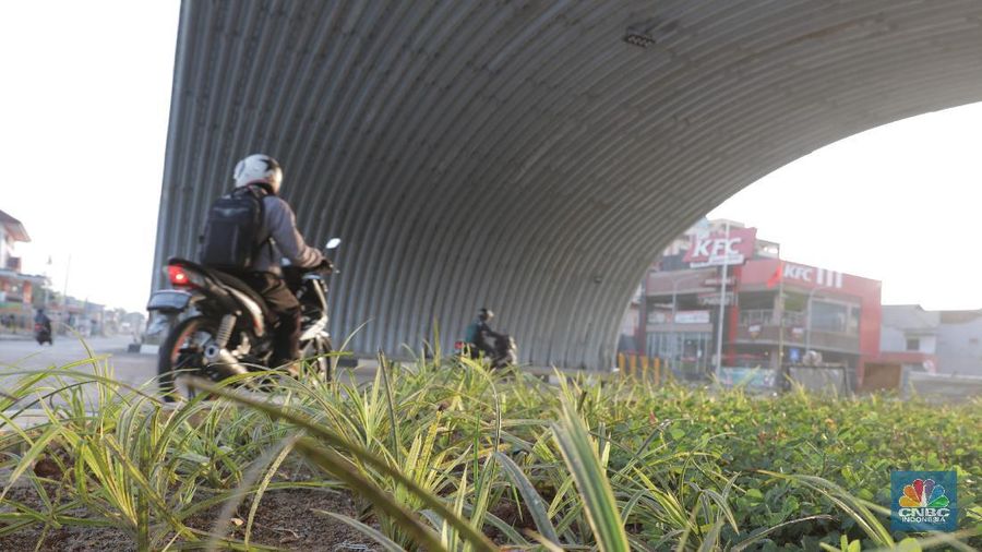 Pengendara melintas di flyover Gaplek di Pondok Cabe, Pamulang, Tangerang,  Jumat, (29/5). Flyover ini memiliki 1 kilometer sepanjang Jalan Raya Jakarta-Bogor, memiliki lebar 35 meter. Jalan layang ini menghubungkan lalu lintas dari arah Ciputat menuju Parung. Pembangunan flyover dinilai mampu mengurangi kemacetan di simpang Gaplek pada pagi. Proyek ini telah berjalan sejak Desember 2019. Flyover ini memiliki tiga terowongan melengkung setengah lingkaran di bawah lintasan flyover. Proyek berjalan dengan nilai kontrak sebesar Rp 79,9 miliar dengan sistem multiyears contract. Pemerintah sendiri menganggarkan Rp 98,4 miliar untuk proyek ini. Anggaran itu berasal dari APBN 2019-2020 Kementerian PUPR. (CNBC Indonesia/ Muhammad Sabki)