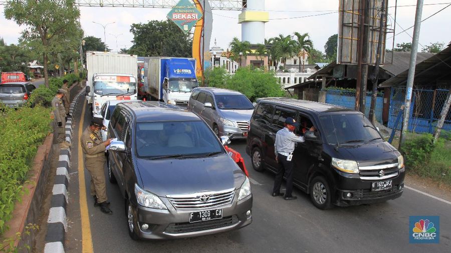 Petugas Dinas Perhubungan (Dishub) akan melakukan pemeriksaan terhadap pengguna kendaraan yang akan memasuki wilayah DKI Jakarta di wilayah perbatasan Bekasi-Karawang, Jawa Barat, Jumat (29/5/2020). Berdasarkan data Dishub Provinsi DKI Jakarta per Rabu (27/5) malam, sebanyak 6.364 kendaraan telah dikembalikan karena mencoba memasuki wilayah Jakarta tanpa memiliki Surat Izin Masuk-Masuk (SIKM) di masa arus balik Lebaran 2020. CNBC Indonesia/Tri Susilo
Tim Gugus Tugas Percepatan Penanganan Covid-19 Kabupaten Karawang, Jabar, menyatakan, terdapat delapan check point atau penyekatan kendaraan pemudik di wilayah Karawang.
Delapan titik check point itu di antaranya di Jembatan Tanjungpura, Jembatan Sian Djin Kupoh, Kobak Biru, Cibeet, Jembatan Rengasdengklok-Bekasi, Jembatan Batujaya-Bekasi, dan ada dua pos di Karawang Kota.
Pencegahan pergerakan pemudik itu berkaitan dengan upaya pemerintah yang melarang mudik pada Lebaran tahun ini sebagai bagian dari mencegah penyebaran virus corona.
Pantauan CNBC Indonesia dilapangan masih banyak pengendara yang masih melanggar peraturan yang sudah ditetapkan oleh pemerintah, contoh surat Surat Izin Keluar Masuk (SIKM).
Warga yang kedapatan tidak memiliki surat (SIKM) akan diputar balik.
Salah satu warga yang mudik dari Tegal, Jawa Tengah menggunakan sepeda motor diberhentikan oleh petugas pengaman perihal SIKM yang tidak ia miliki, tetapi dirinya mempunyai surat jalan untuk pulang ke Jakarta dari pihak kepolisian di Jawa Tengah. (CNBC Indonesia/ Tri Susilo)