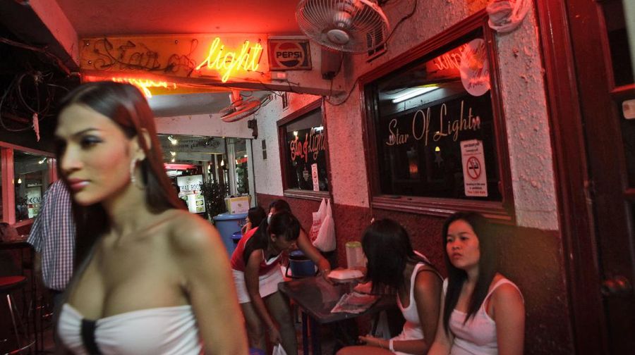 Thai dance bar girls sit outside their bar in Patpong area, near to the anti-government protesters encampment, which re-opened after a gap of two weeks, with precautionary midnight to early morning curfew in downtown Bangkok, Thailand, May 25, 2010. (AP Photo/ Manish Swarup)