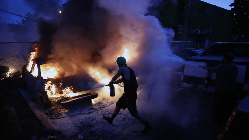 A masked protester kneels before San Jose police on Friday, May 29, 2020, in San Jose, Calif., in response to the death of George Floyd in police custody on Memorial Day in Minneapolis. (AP Photo/Ben Margot)