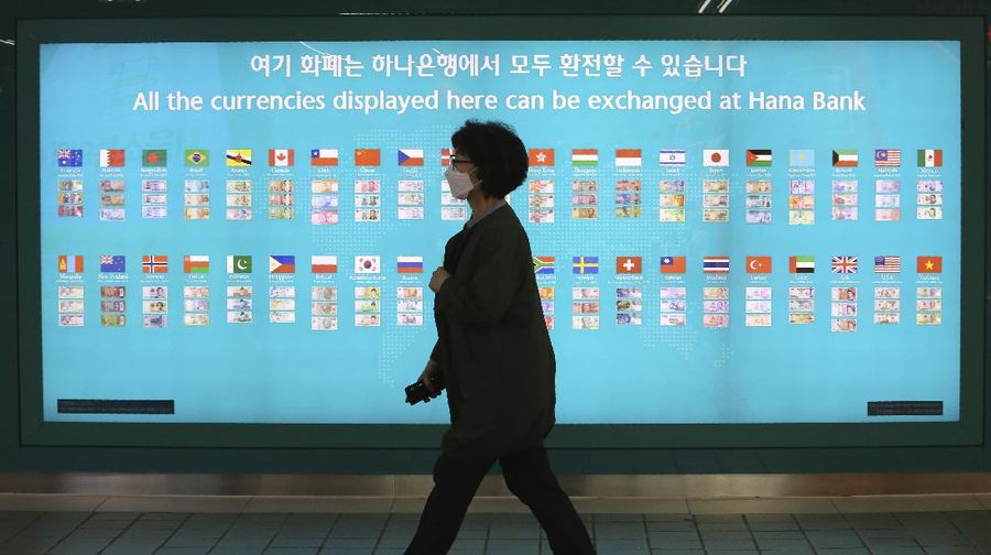 A woman wearing a face mask walks by a board displaying the world banks' notes at a subway station in Seoul, South Korea, Thursday, May 28, 2020. South Korea’s central bank lowered its policy rate to an all-time low of 0.5% to soften the pandemic’s shock to the country’s trade-dependent economy, which it says may shrink for the first time in 22 years. (AP Photo/Ahn Young-joon)