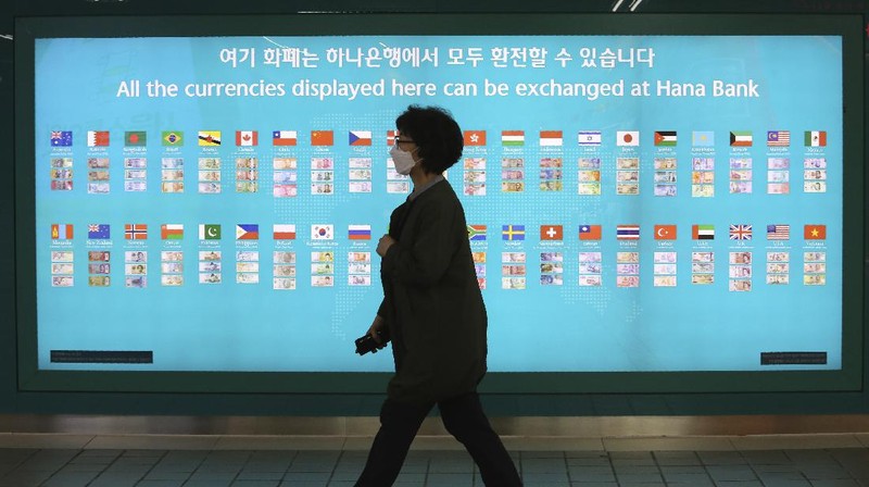 A woman wearing a face mask walks by a board displaying the world banks' notes at a subway station in Seoul, South Korea, Thursday, May 28, 2020. South Korea’s central bank lowered its policy rate to an all-time low of 0.5% to soften the pandemic’s shock to the country’s trade-dependent economy, which it says may shrink for the first time in 22 years. (AP Photo/Ahn Young-joon)