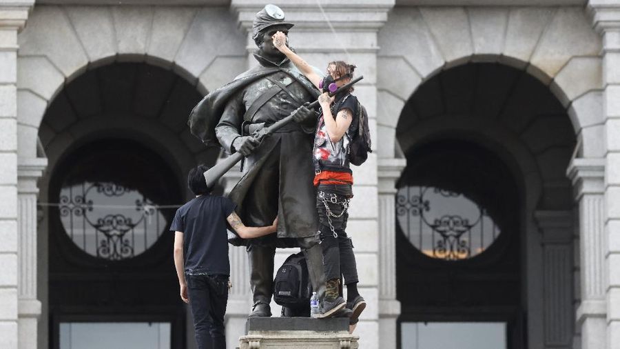 A masked protester kneels before San Jose police on Friday, May 29, 2020, in San Jose, Calif., in response to the death of George Floyd in police custody on Memorial Day in Minneapolis. (AP Photo/Ben Margot)