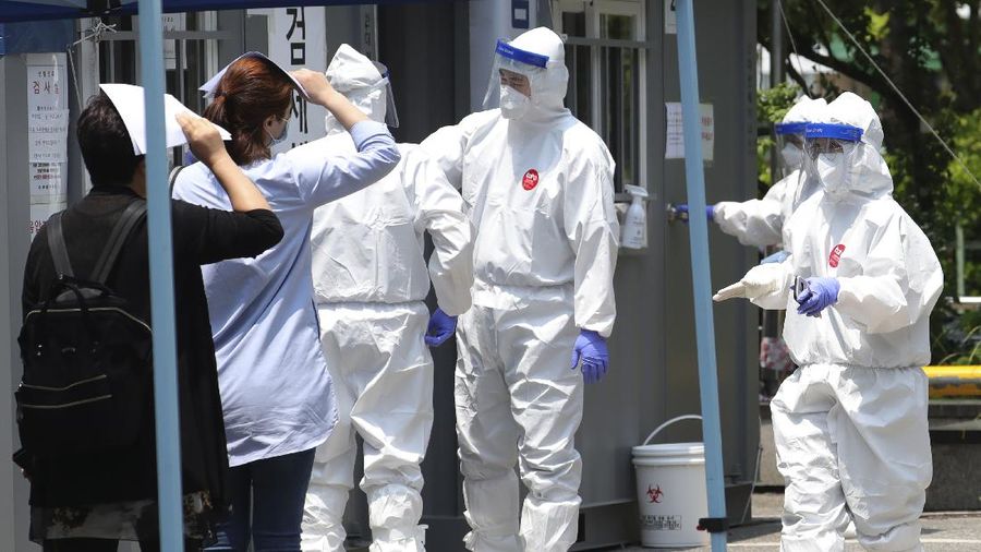 People suspected of being infected with the new coronavirus wait to receive tests at a coronavirus screening station in Bucheon, South Korea, Thursday, May 28, 2020. South Korea on Thursday reported its biggest jump in coronavirus cases in more than 50 days, a setback that could erase some of its hard-won gains. Health officials warned that the resurgence is getting harder to track and social distancing and other steps need to be taken. (Yun Hyun-tae/Yonhap via AP)