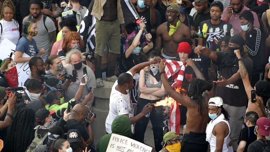 A masked protester kneels before San Jose police on Friday, May 29, 2020, in San Jose, Calif., in response to the death of George Floyd in police custody on Memorial Day in Minneapolis. (AP Photo/Ben Margot)