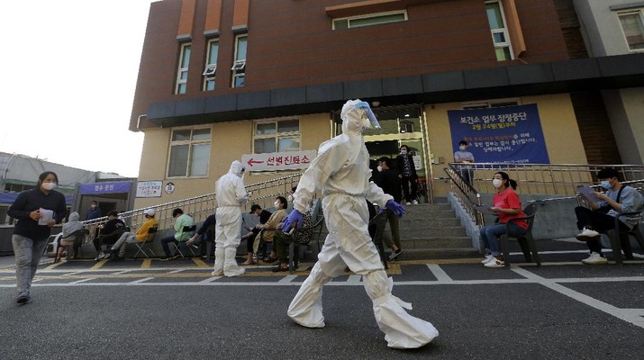 Wabah Virus di Korea Selatan (AP/Ahn Young-joon) A woman wearing a face mask walks by a board displaying the world banks' notes at a subway station in Seoul, South Korea, Thursday, May 28, 2020. South Korea’s central bank lowered its policy rate to an all-time low of 0.5% to soften the pandemic’s shock to the country’s trade-dependent economy, which it says may shrink for the first time in 22 years. (AP Photo/Ahn Young-joon)
