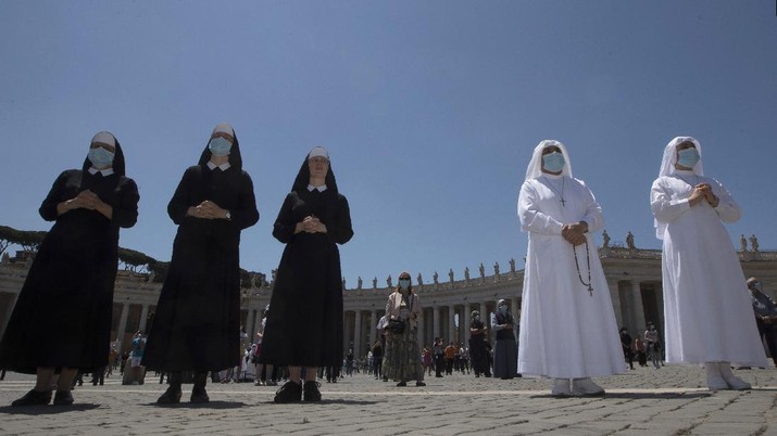 A nun wearing gloves to prevent the spread of COVID-19 listens to Pope Francis in St. Peter's Square, at the Vatican, Sunday, May 31, 2020, Sunday, May 31, 2020. Pope Francis has cheerfully greeted people in St. Peter’s Square on Sunday, as he resumed his practice of speaking to the faithful there for the first time since lockdown began in Italy and at the Vatican in early March. Instead of the tens of thousands of people who might have turned out on a similarly brilliantly sunny day like this Sunday, in pre-pandemic times, perhaps a few hundred came to the square, standing well apart from others or in small family groups. (AP Photo/Alessandra Tarantino)