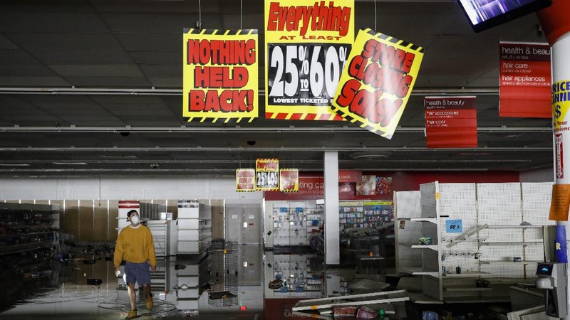 A woman carries merchandise from a Union Square Victoria's Secret store in San Francisco on Saturday, May 30, 2020. Widespread vandalizing occurred at stores throughout San Francisco following the death of George Floyd, a handcuffed black man in police custody in Minneapolis. (AP Photo/Noah Berger)