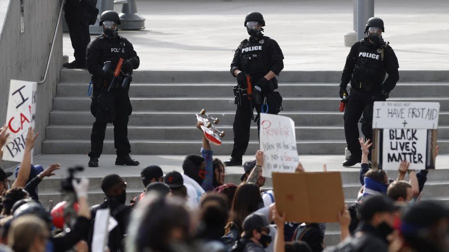 People hold signs during a protest over the death of George Floyd in Chicago, Saturday, May 30, 2020. Protests were held throughout the country over the death of Floyd, a black man who died after being restrained by Minneapolis police officers on May 25.(AP Photo/Nam Y. Huh)