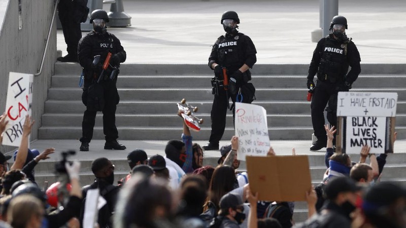 People hold signs during a protest over the death of George Floyd in Chicago, Saturday, May 30, 2020. Protests were held throughout the country over the death of Floyd, a black man who died after being restrained by Minneapolis police officers on May 25.(AP Photo/Nam Y. Huh)