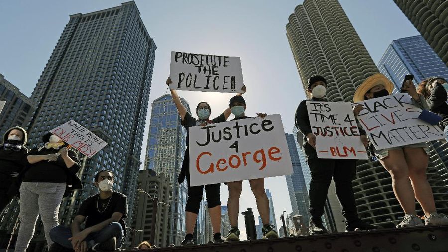 People hold signs during a protest over the death of George Floyd in Chicago, Saturday, May 30, 2020. Protests were held throughout the country over the death of Floyd, a black man who died after being restrained by Minneapolis police officers on May 25.(AP Photo/Nam Y. Huh)