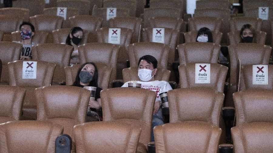a movie goer wears a face mask to help curb the spread of the coronavirus as he buys ticket at the Paragon Cineplex movie theater in Bangkok, Thailand, Monday, June 1, 2020. Thai authorities allowed movie theater and other businesses to reopen, selectively easing restrictions against the coronavirus. (AP Photo/Sakchai Lalit)