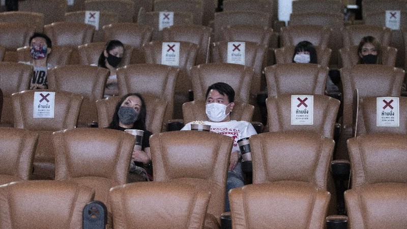 a movie goer wears a face mask to help curb the spread of the coronavirus as he buys ticket at the Paragon Cineplex movie theater in Bangkok, Thailand, Monday, June 1, 2020. Thai authorities allowed movie theater and other businesses to reopen, selectively easing restrictions against the coronavirus. (AP Photo/Sakchai Lalit)